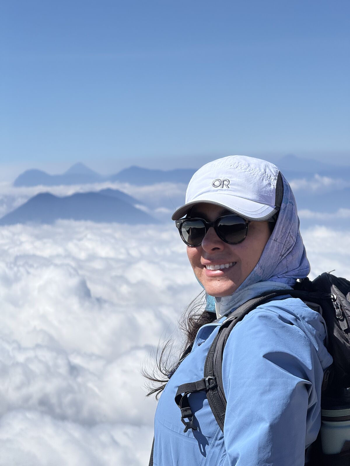 Andrea Cardona sonríe en la cumbre del Acatenango, por encima de las nubes