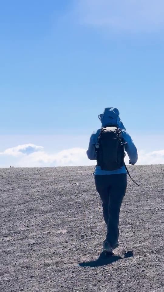 Andrea camina por la arena volcánica cerca de la cima del Acatenango, sobre las nubes